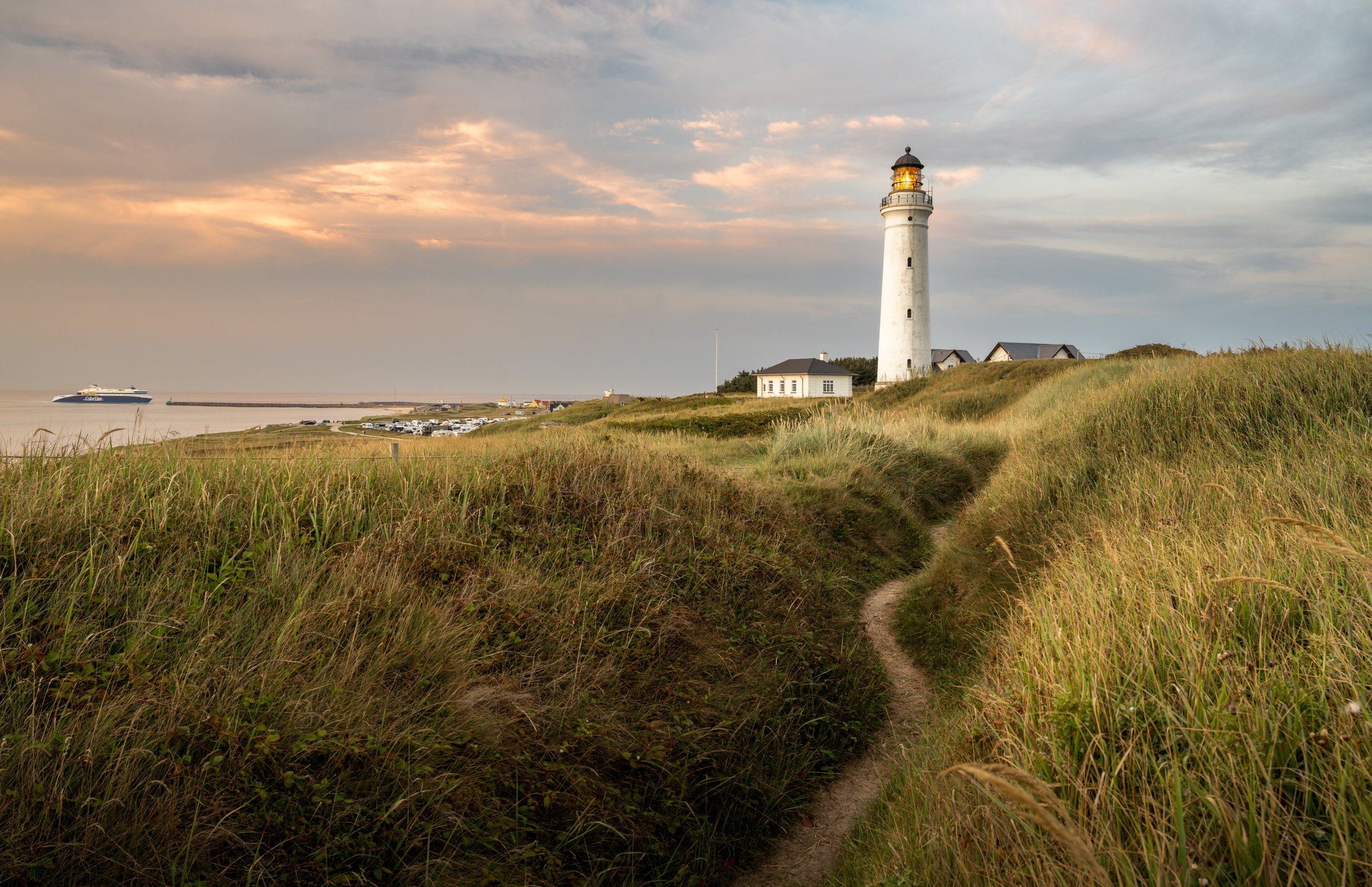 Der Leuchtturm von Hirtshals an der dänischen Nordseeküste, im Hintergrund eine Fähre. Von hier startet die Norröna zu ihrer Durchfahrt nach Island.