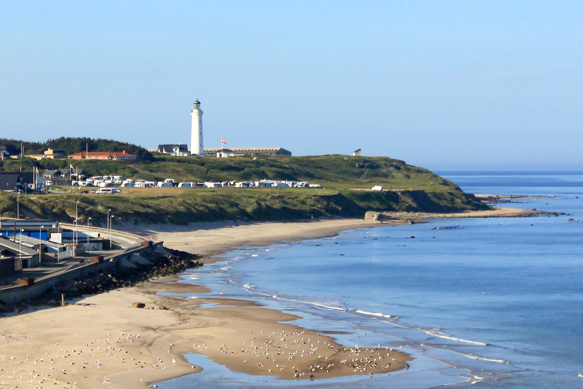 Der Leuchtturm von Hirtshals über dem Sandstrand an der dänischen Nordseeküste. Von hier legt die Norröna auf die Färöer ab.